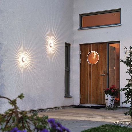 Monza LED applique extérieure à effet sur un mur de maison à côté de la porte d’entrée, éclairant l’espace extérieur.