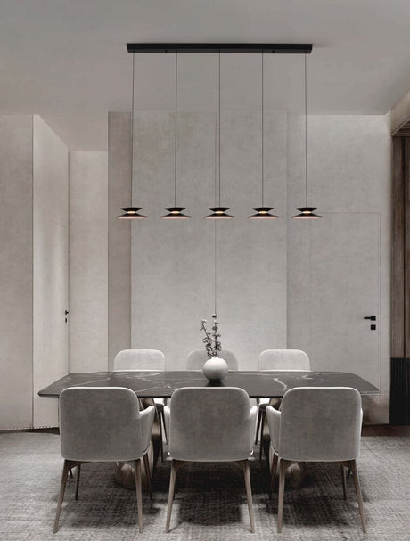 Morfi pendant light bar 132cm 5-light 3000K black, gold above an elegant dining area.