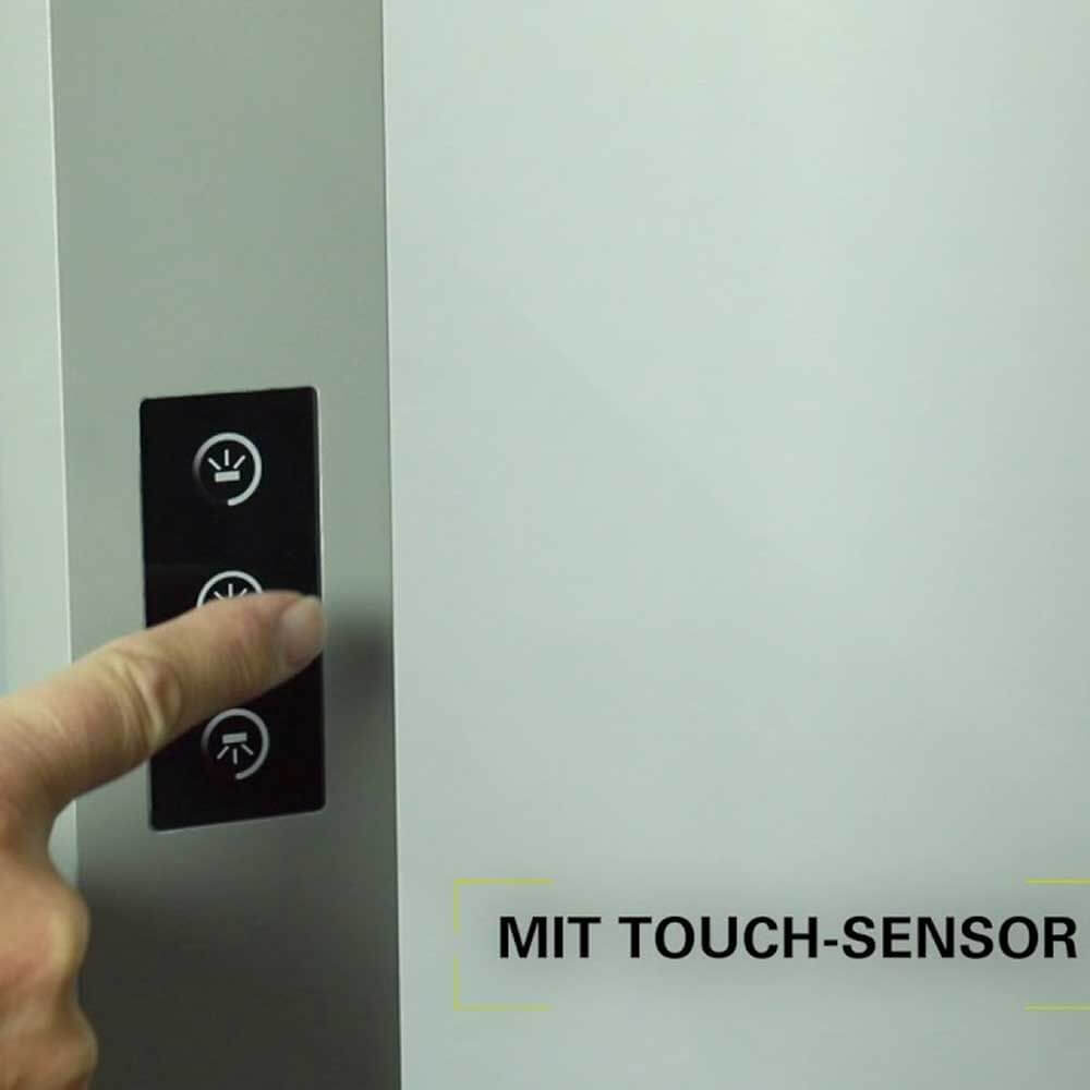 Benutzer betätigt den Touch-Sensor eines LED-Bürolampe mit Bewegungsmelder und Tageslichtsensor.