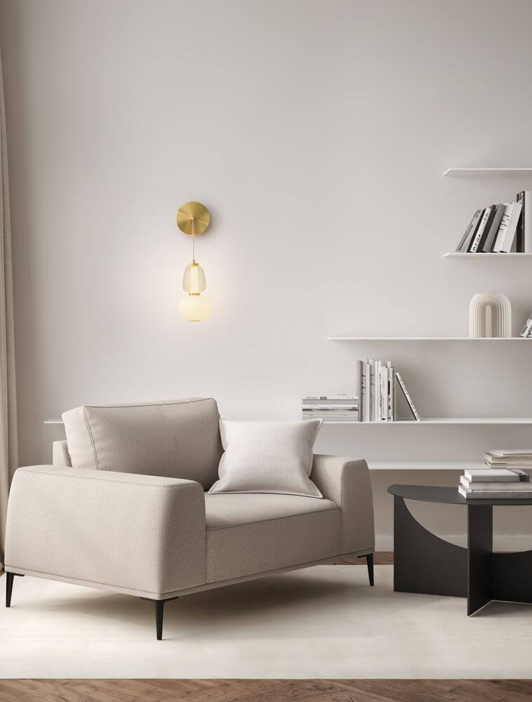 Moderne Einrichtung mit Movil Wandleuchte 3000K Gold über einem beigen Sessel und minimalistischer Regalwand.