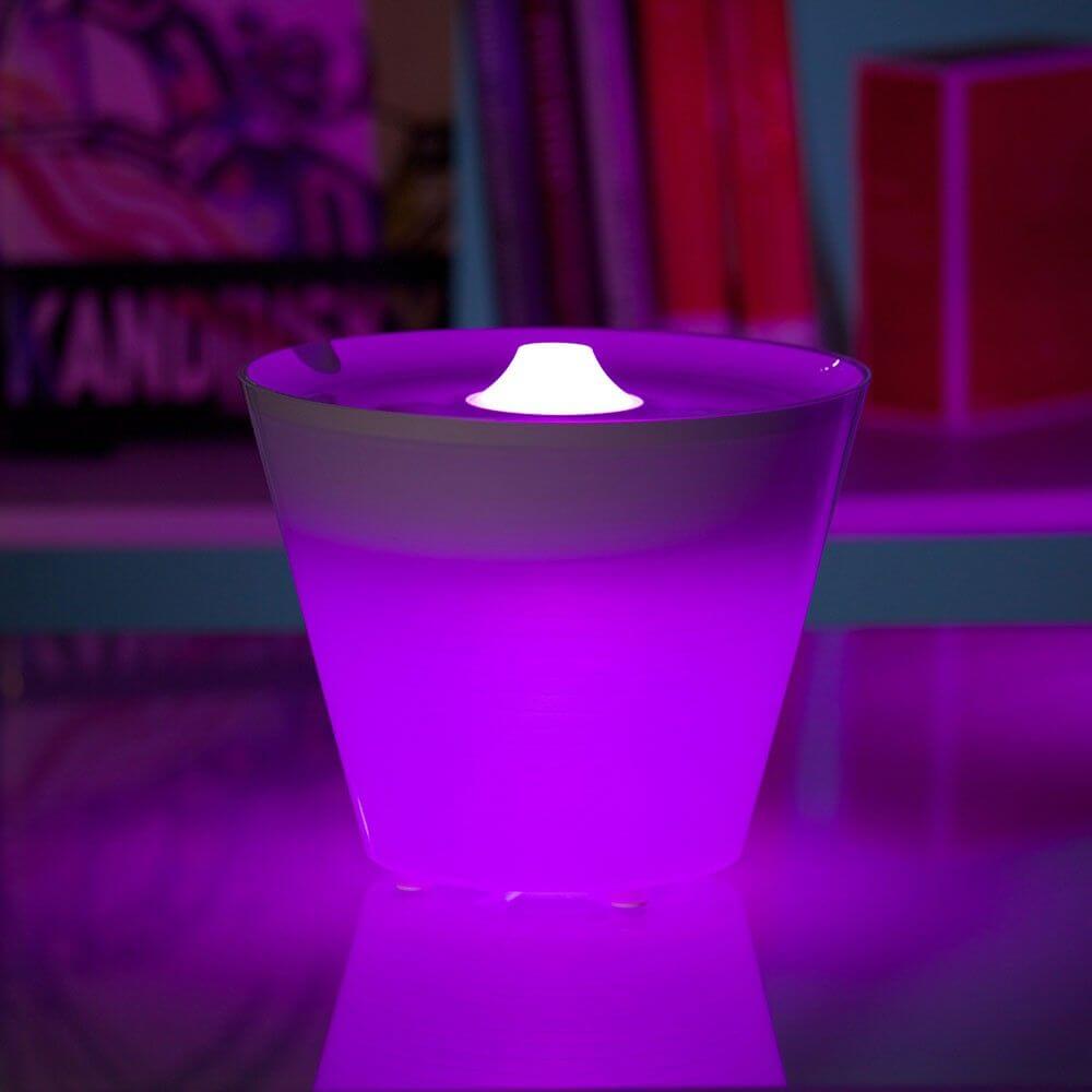 Rotaliana Multipot+ table lamp cable container + charging station white in purple illuminated design on table.