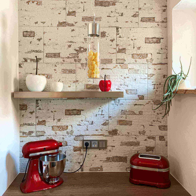 Moderne Küche mit rotem Standmixer, Toaster und Holzregal vor einer Steinwand.