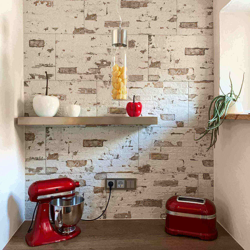 Moderne Küche mit rotem Standmixer, Toaster und Holzregal vor einer Steinwand.