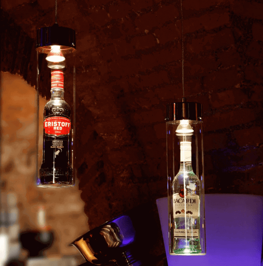 Hängende Flaschenleuchten mit Eristoff und Bacardi in stilvoller Bar-Umgebung