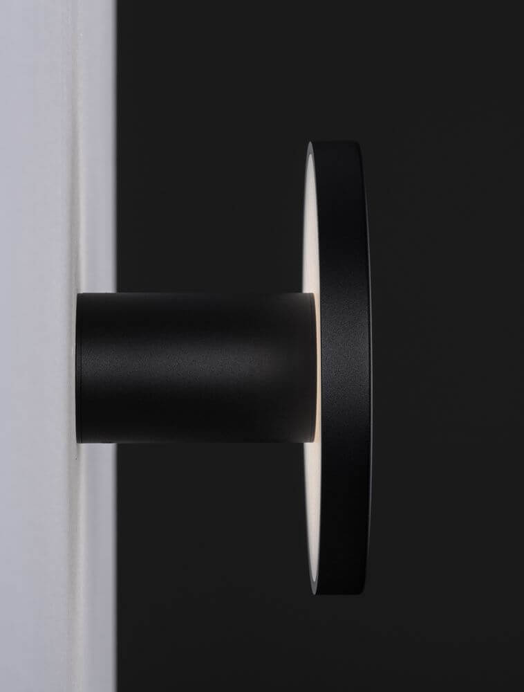 Nano Wandleuchte 3000K Schwarz an weißer Wand, modernes rundes Design mit warmweißem Licht