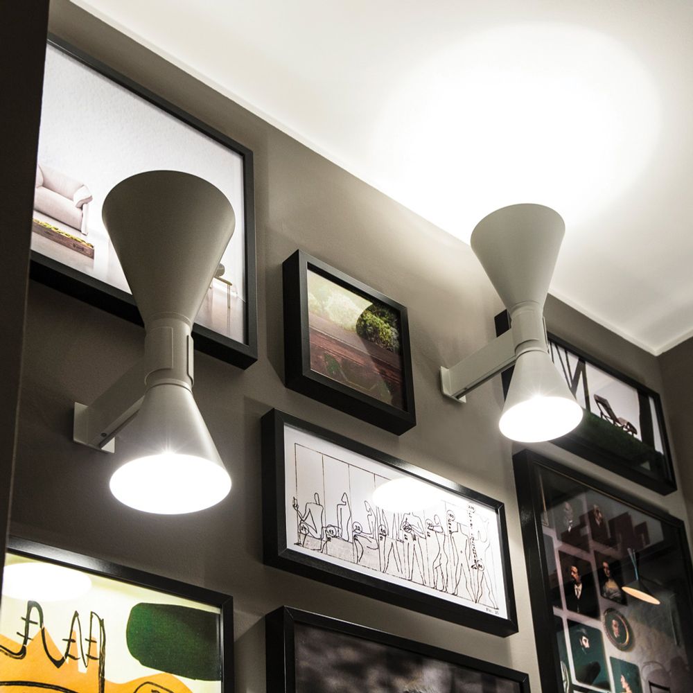 Zwei Nemo Applique De Marseille Wandlampen Up&Down an einer Wand mit Rahmenkunstwerken.