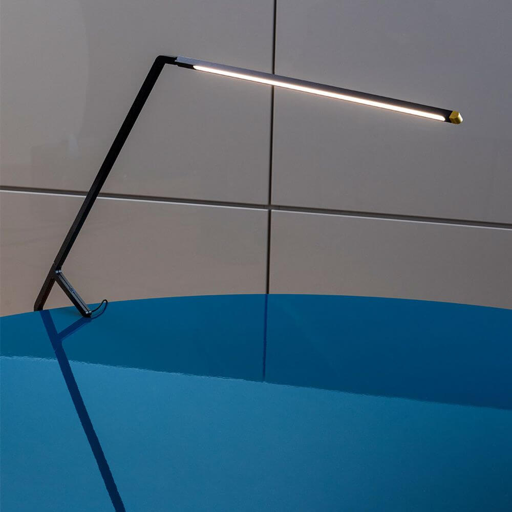 Nemo Bird LED Tischlampe mit Gestensteuerung auf einem blauen Tisch, elegantes Design und moderne Funktionalität.