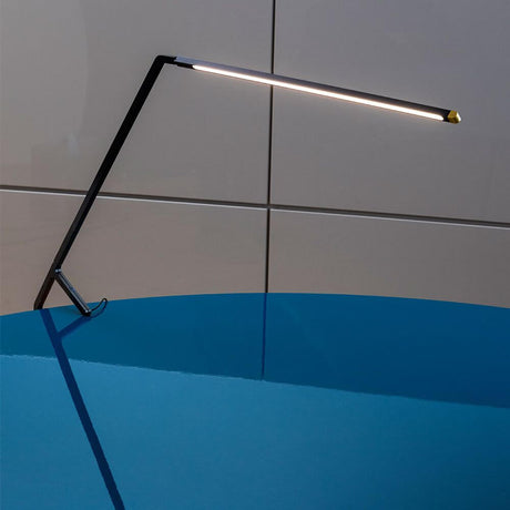 Nemo Bird LED Tischlampe mit Gestensteuerung auf einem blauen Tisch, elegantes Design und moderne Funktionalität.