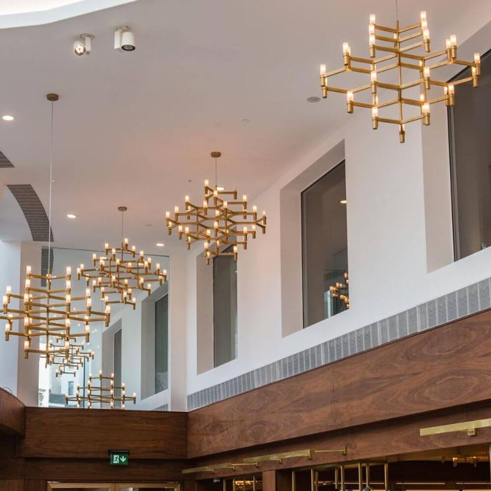 Moderne Kronleuchter im Restaurant, inspiriert von Schneekristallen, aus goldfarbenem Aluminium und Glas.