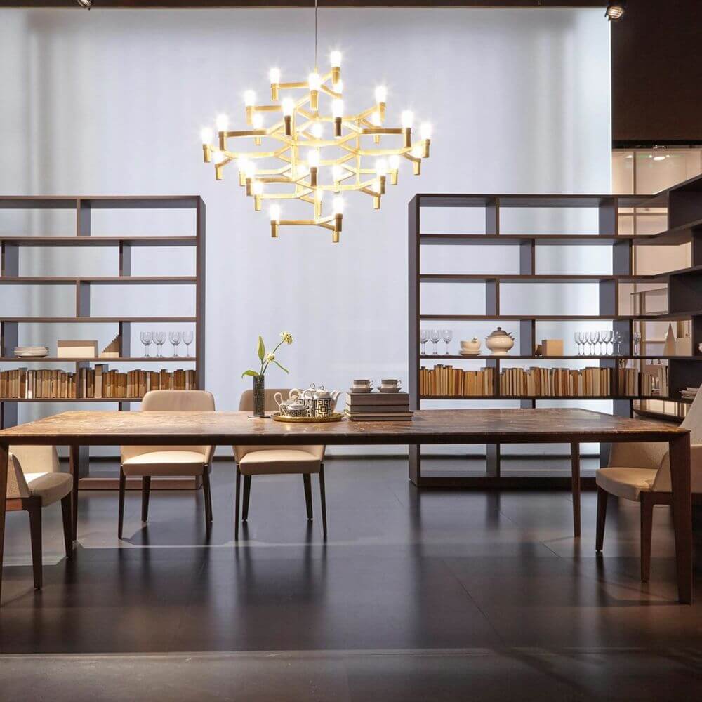 Nemo Crown Major Hängelampe im eleganten Esszimmer mit Holzregalen und stilvollem Tisch.