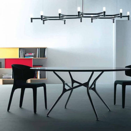 Nemo Crown Plana Major luminaire de table à manger 12 lumières 186 cm au-dessus d’une table à manger moderne avec des chaises noires.