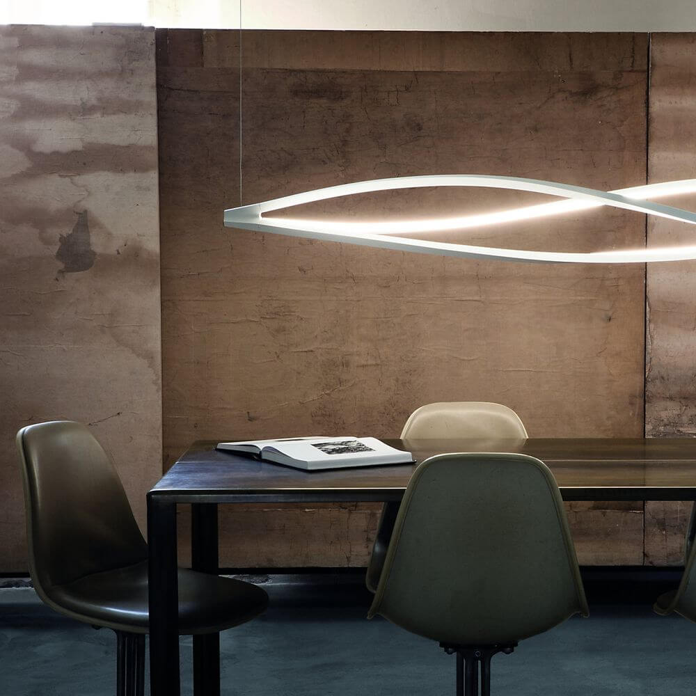 Nemo In The Wind Horizontal LED Hängelampe 183cm über einem Tisch mit stilvollen Stühlen in einem modernen Raum.
