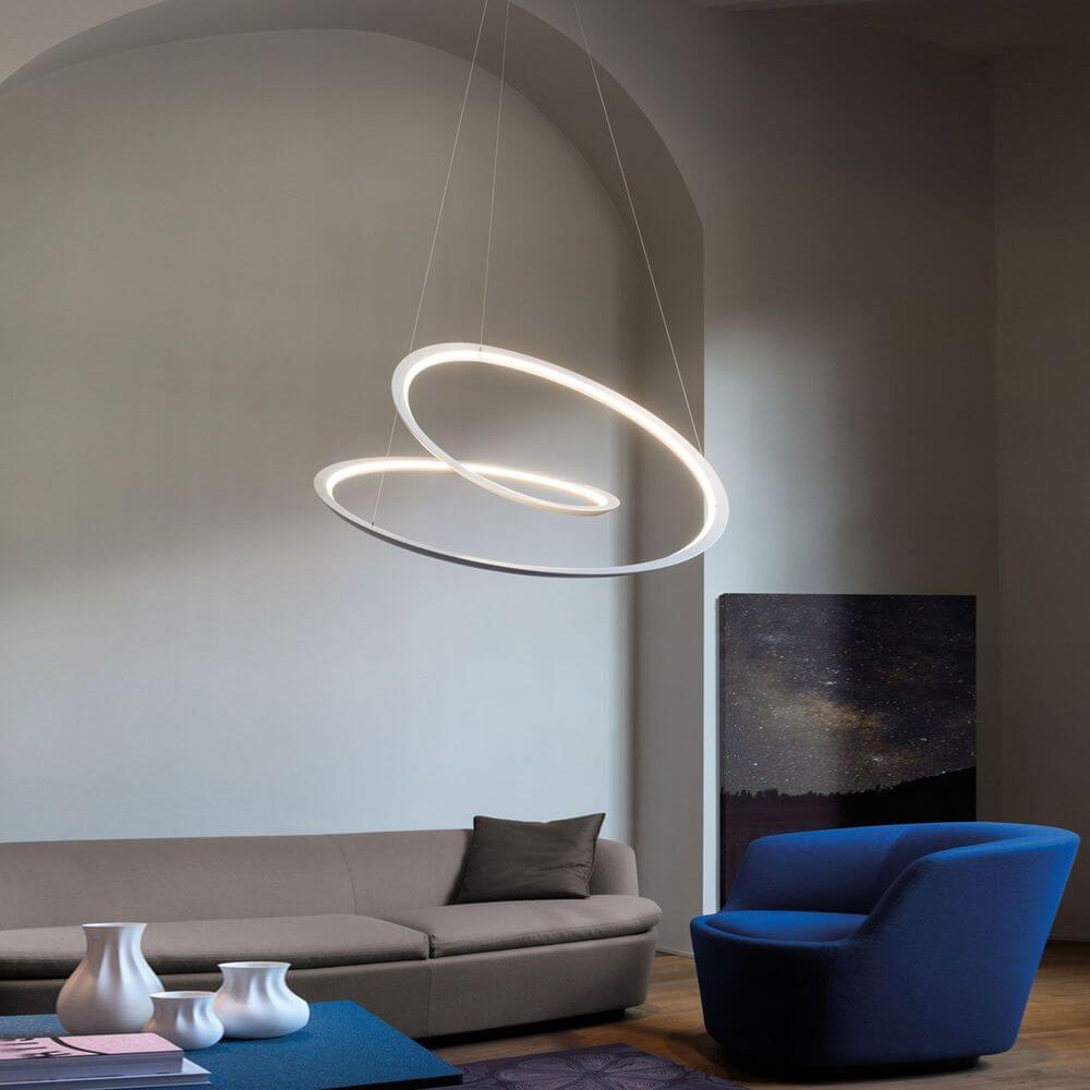 Nemo Kepler Up LED Pendelleuchte Ø 110cm in modernem Wohnraum über gemütlichem Sofa und blauem Sessel.