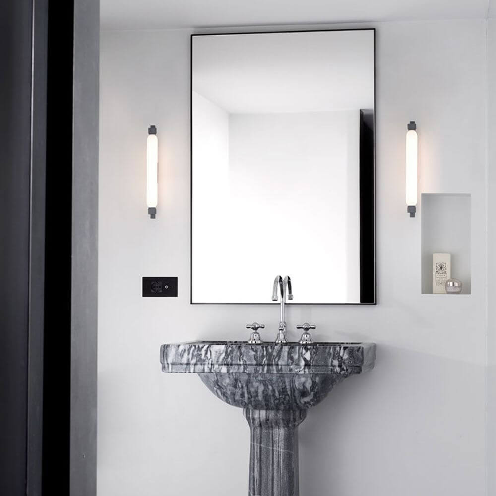 Nemo La Roche LED Wandlampe neben einem modernen Badezimmer Spiegel und Marmorbasis.