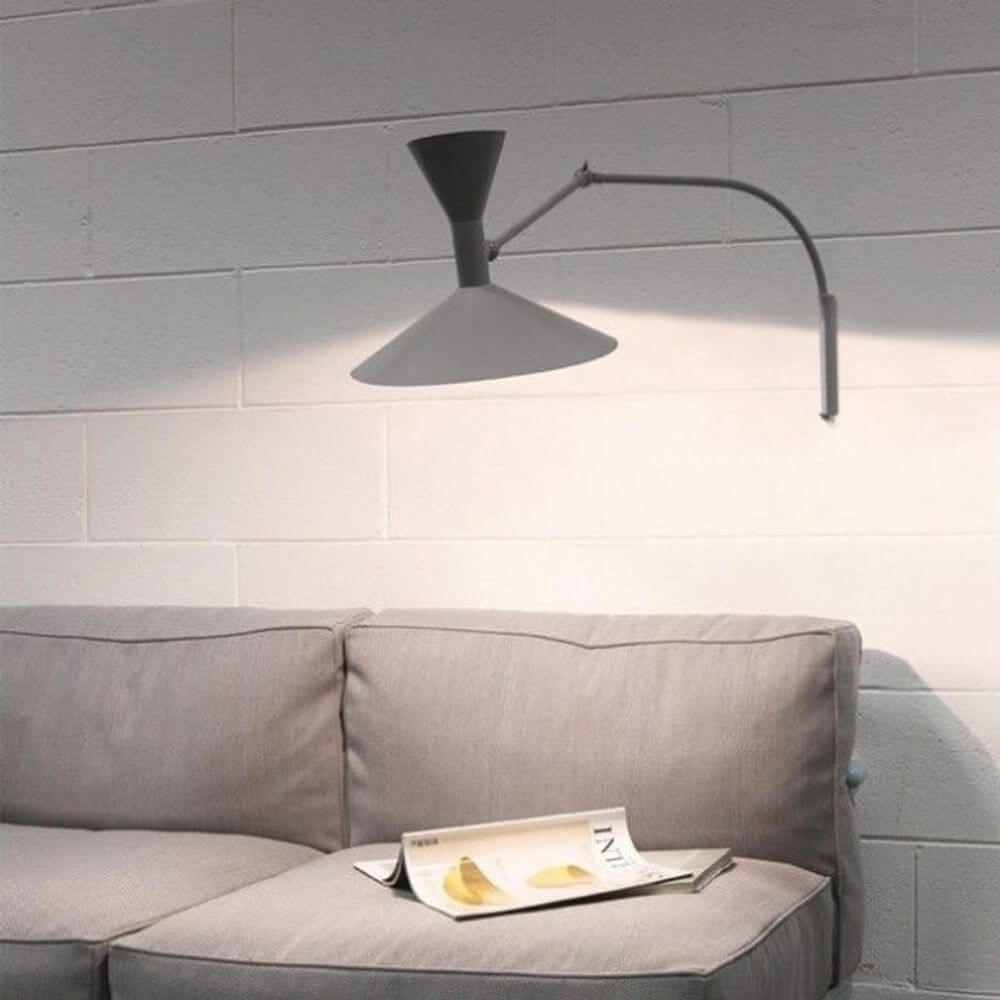 Nemo Lampe De Marseille Mini Wandleuchte mit Arm über einem grauen Sofa, stilvolle Beleuchtung im Raum.