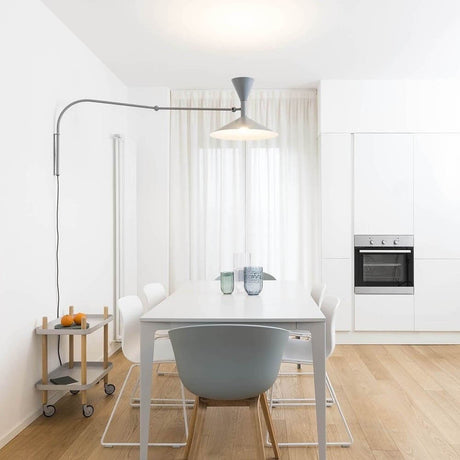 Nemo Lampe De Marseille wall light with arm in a modern dining room with table and chairs