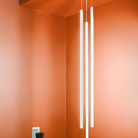 Nemo Linescapes Vertical LED Hängelampe 115cm in einem modernen Interieur mit oranger Wandfarbe.