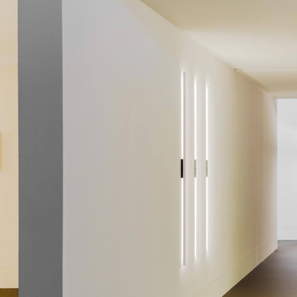 Moderne Nemo Linescapes Wall 102 LED Wandleuchte an einer weißen Wand in einem eleganten Flur.
