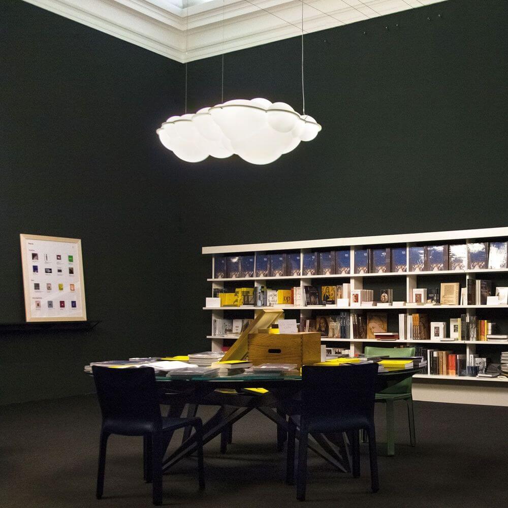 Nemo Nuvola LED Hängelampe Wolke 154cm in modernem Raum über einem Tisch mit Büchern und Stühlen.