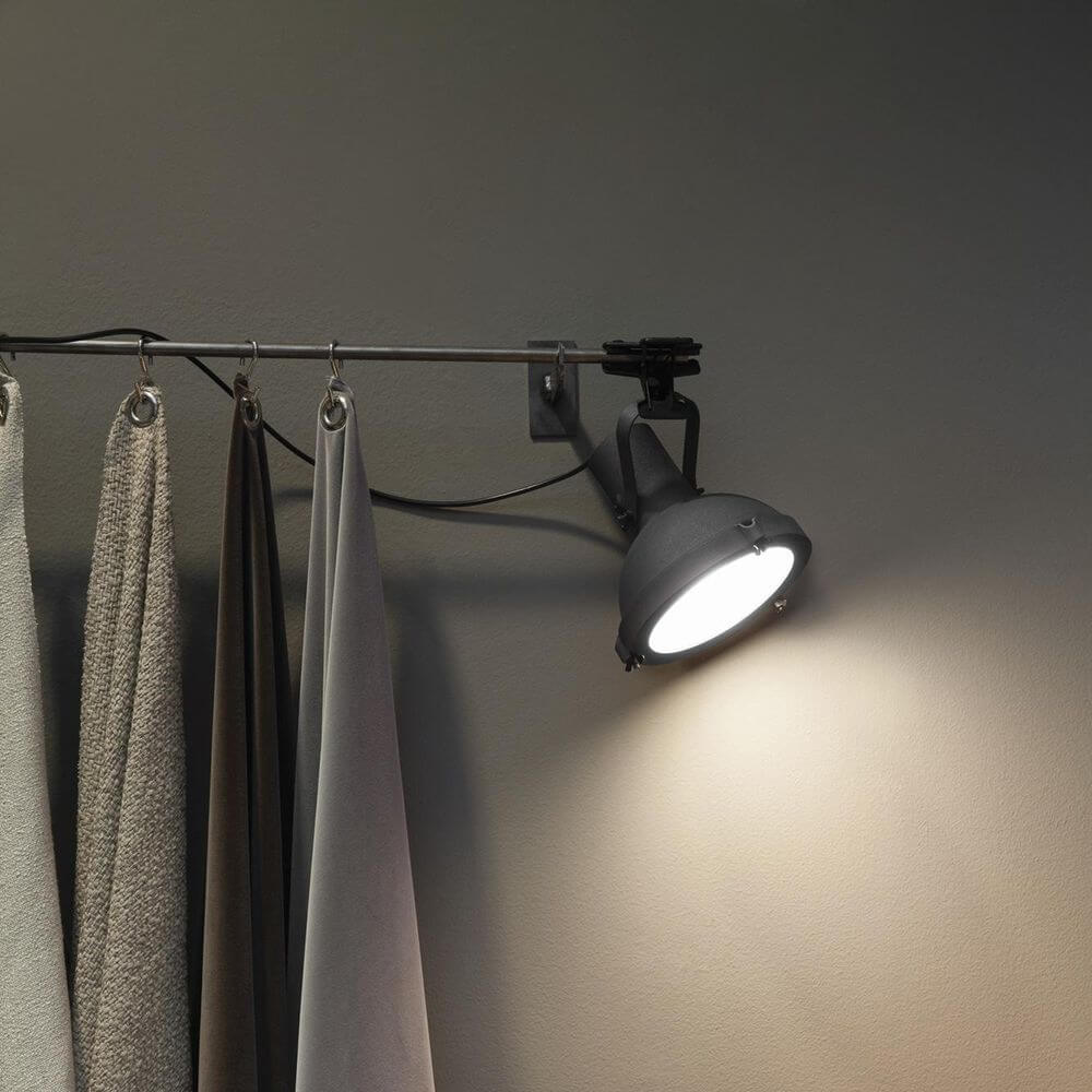 Nemo Projecteur 165 Klemmleuchte an einer Stange mit Vorhängen, verstellbare Lichtquelle im modernen Design.