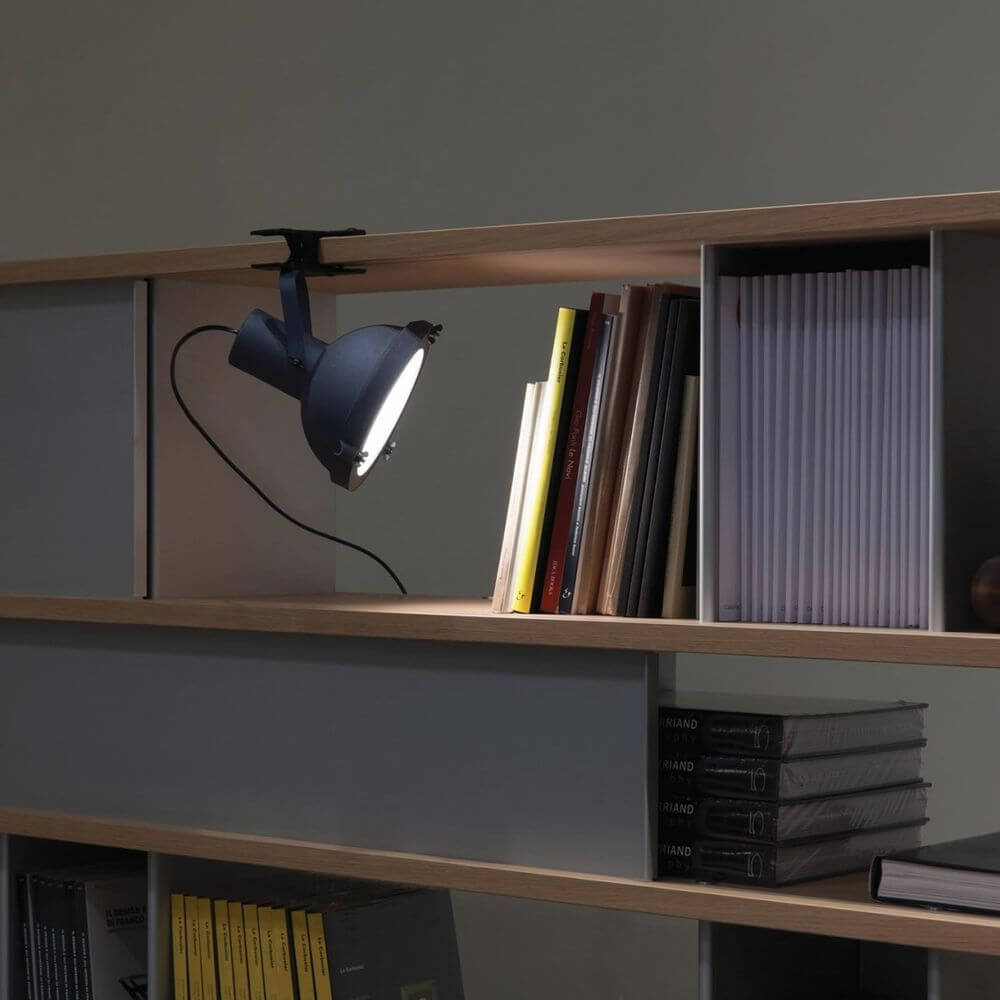 Nemo Projecteur 165 Klemmleuchte an Regal mit Bücher und Akten, verstellbares Lichtdesign.