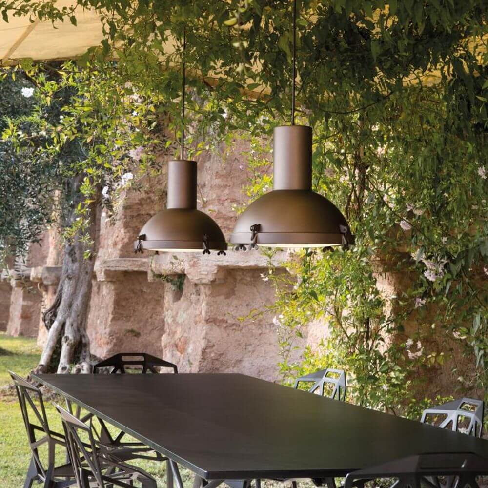 Nemo Projecteur 365 Outdoor Hängelampe IP65 im Garten über einem Tisch mit Stühlen.