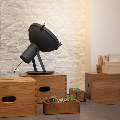 Lampe sur pied Nemo Projecteur 365 sur des tables en bois dans un espace de vie moderne avec des plantes.