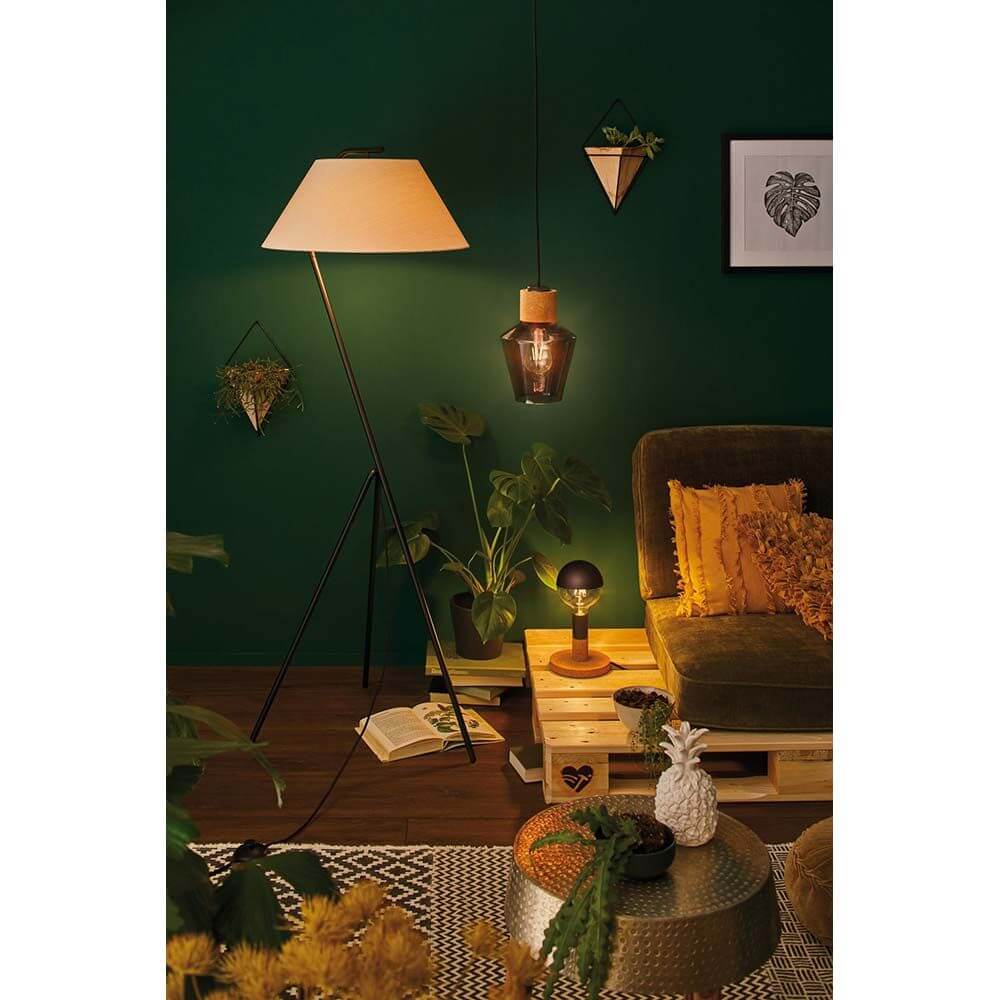 Gemütliche Wohnsituation mit Edla Pendelleuchte und Stehlampe im Urban Jungle Stil, grüne Wand, Pflanzen und Deko.