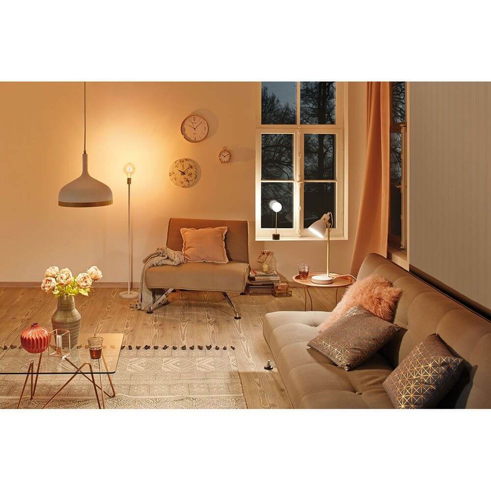 Skandinavisches Wohnzimmer mit Neordic Orm Tischleuchte und moderner Einrichtung in Grau und Kupfer.