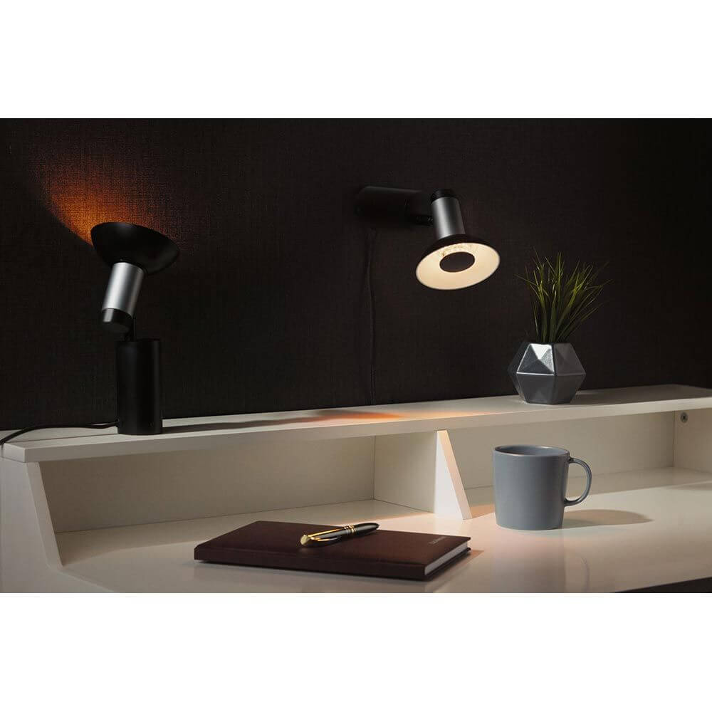 Neordic Runa Wand- & Tischleuchte Schwarz, Anthrazit in einem modernen Wohnraum mit Schreibtisch.