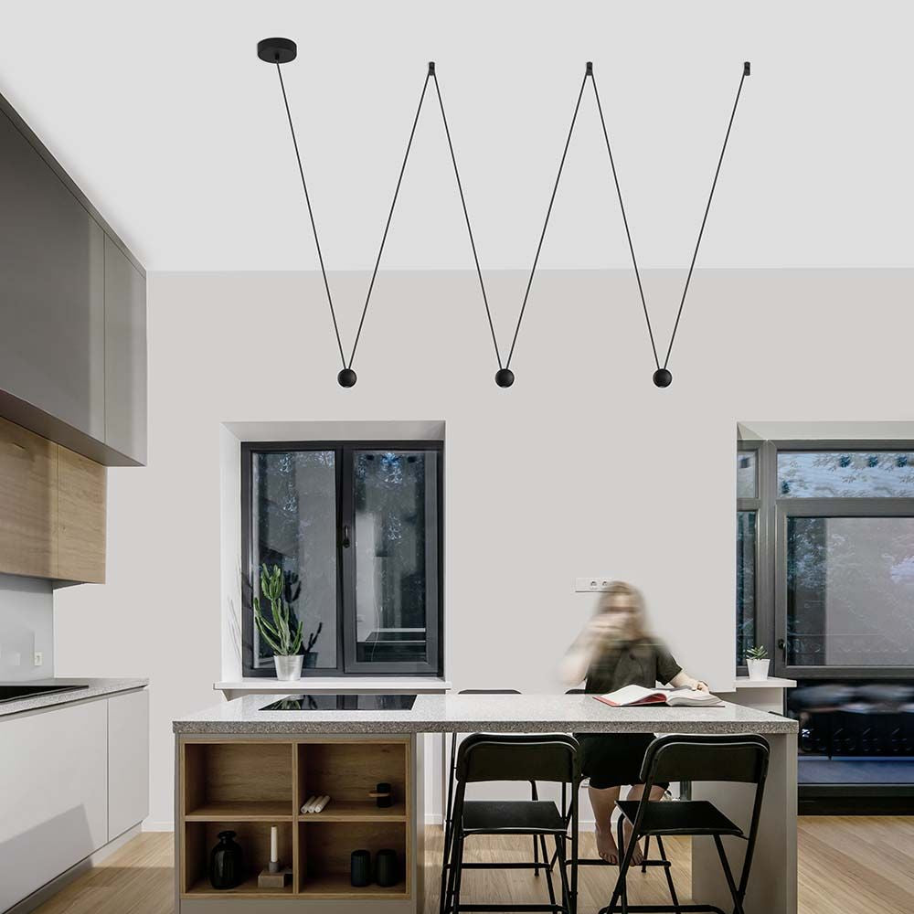 Moderne Nocci LED-Hängelampe 3-flammig in Schwarz über einem stilvollen Kücheninsel. Ideal für Ess- oder Wohnzimmer.