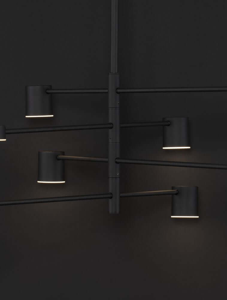 Nordik LED Pendelleuchte 8-flammig Ø 100cm 3000K Schwarz an schwarzer Wand, modernes Design mit warmweißem Licht.