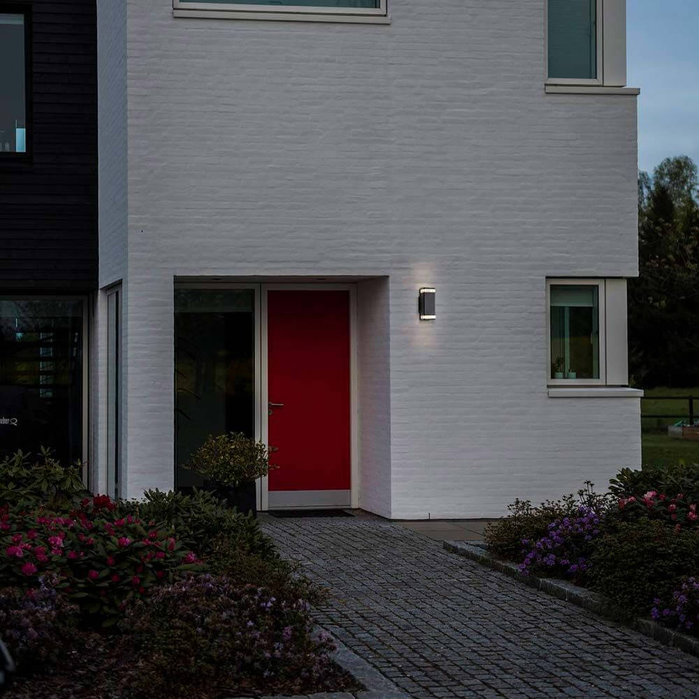 Außen-Wandleuchte Elm IP44 Schwarz, Klar an einem modernen Eingangsbereich mit roter Haustür.