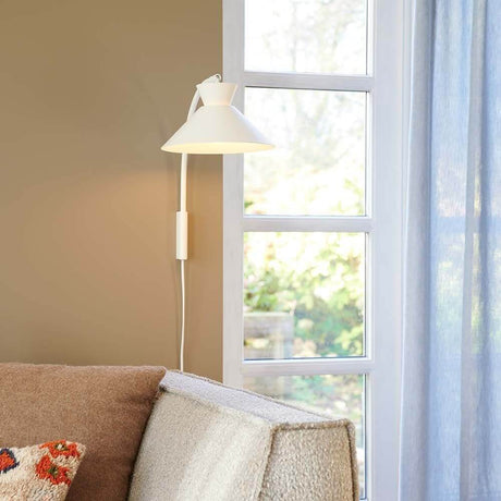 Dial wall light in Scandinavian design, with an open shade for a decorative uplight effect.