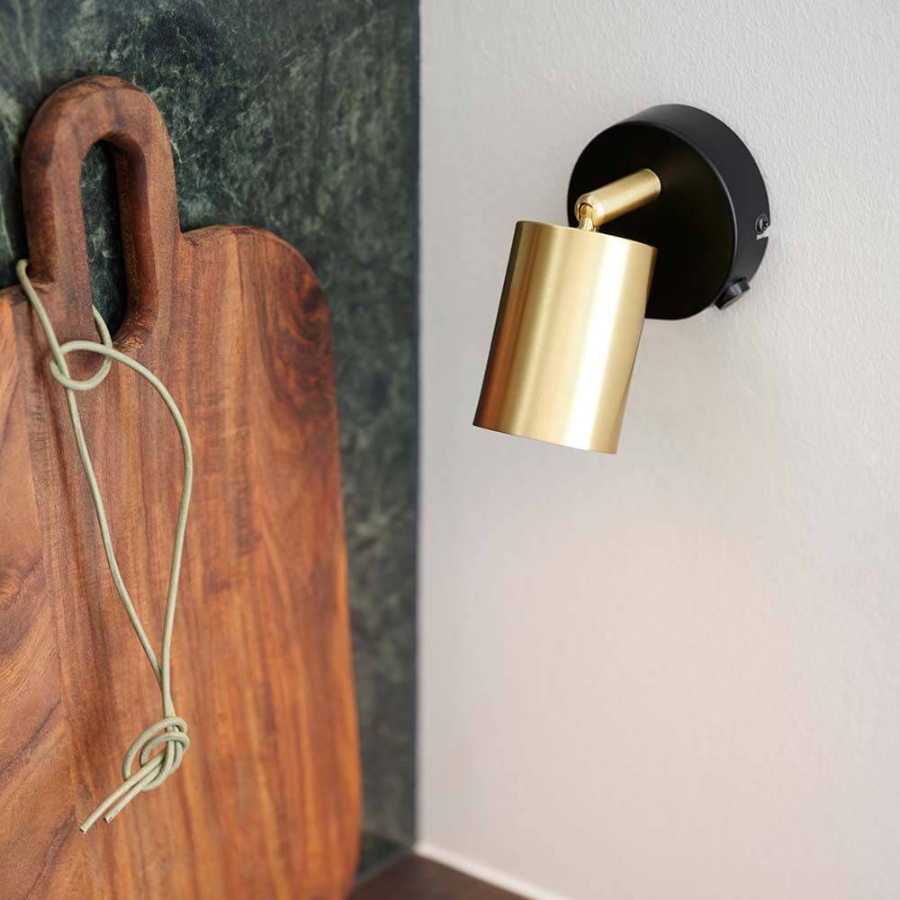 Explore Wand Spot Messing mit verstellbarem Lampenkopf und Holzbrett im Hintergrund.