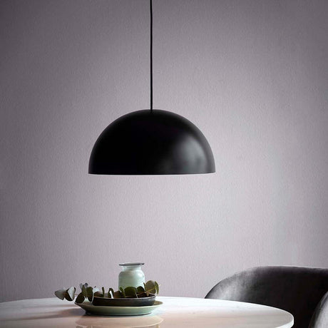 Hängelampe Ellen 40 Schwarz im minimalistischen skandinavischen Design über einem Tisch, der eine stilvolle Beleuchtung bietet.