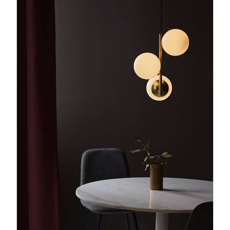Hängeleuchte Lilly Messing, Opalweiß in elegantem Wohnraum über Tisch, stilvolle Beleuchtung.
