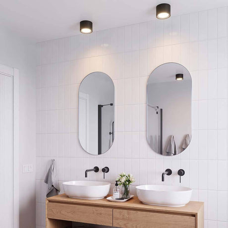 Landon LED Bad Deckenleuchte IP44 im modernen Badezimmer mit eleganten Spiegeln und weißen Waschbecken.