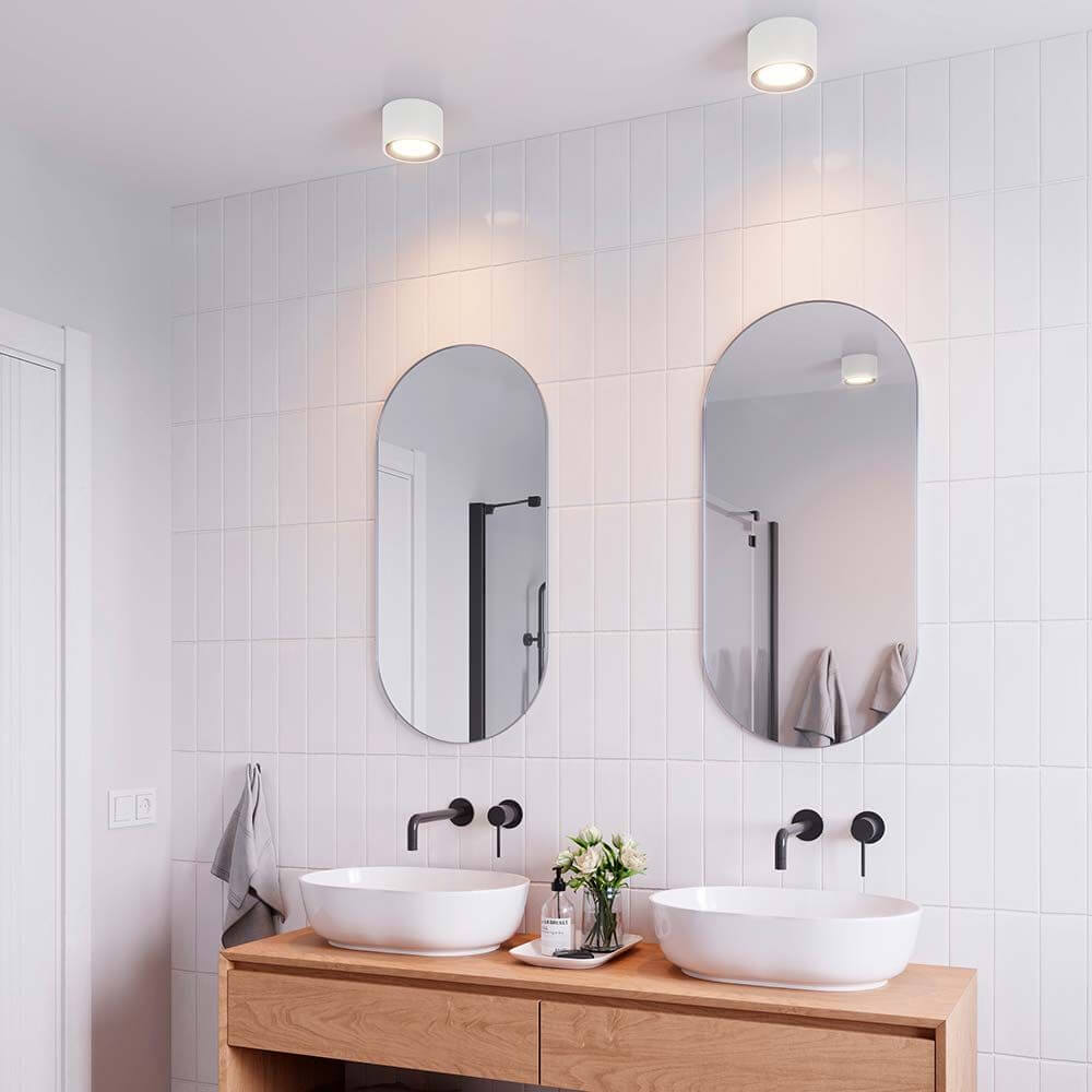 Landon LED Bad Deckenleuchte IP44 in modernem Badezimmer mit Spiegeln und Waschbecken.