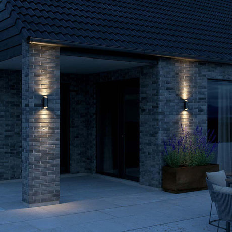 Nico Round utendørs vegglampe med 2 lyskilder på et moderne hus med elegant belysning.