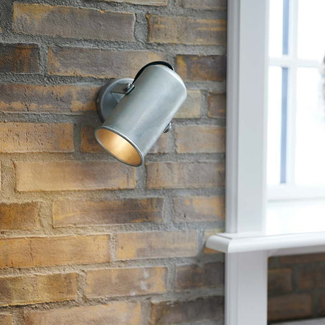 Applique murale Porter spot sur un mur en briques avec tête de luminaire orientable pour un éclairage ciblé.