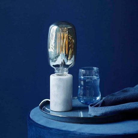 Bordlampe Siv med hvit marmor, stilfull lampe på et brett med glass og stoff.