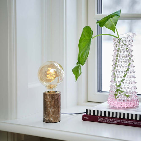 Lampe de table Siv en marbre avec un design en marbre élégant et une lumière chaleureuse dans un intérieur moderne.