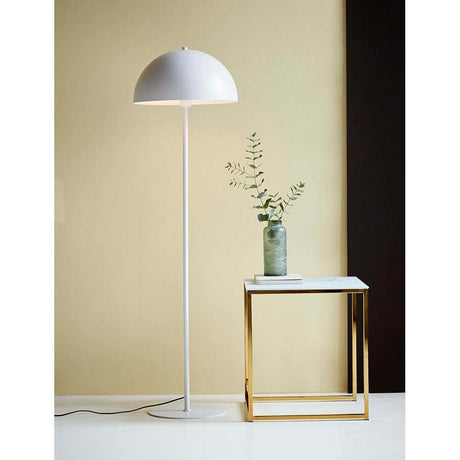Stehlampe Ellen Weiß neben Tisch mit Vase und Pflanze in modernem skandinavischen Design.