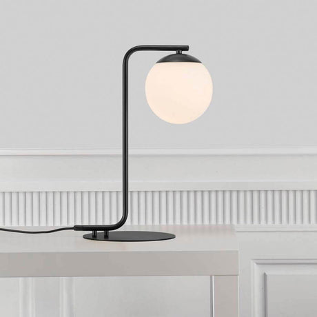 Tischlampe Grant Schwarz, Opal Weiß auf einem Tisch mit eleganter, minimalistischer Gestaltung.