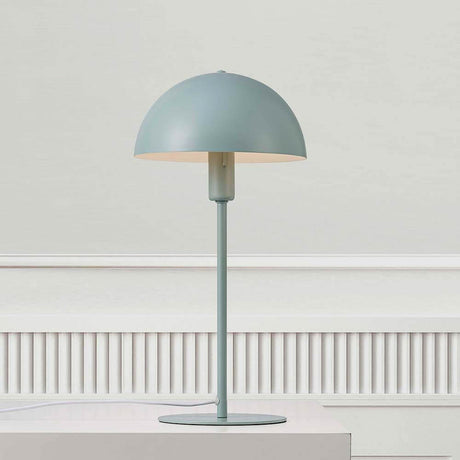 Lampe de table Ellen vert pastel au design élégant avec abat-jour rond et structure légère.