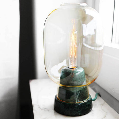 Lampada da tavolo nostalgica Amp Gold, Verde con design elegante in marmo e vetro su un tavolo.