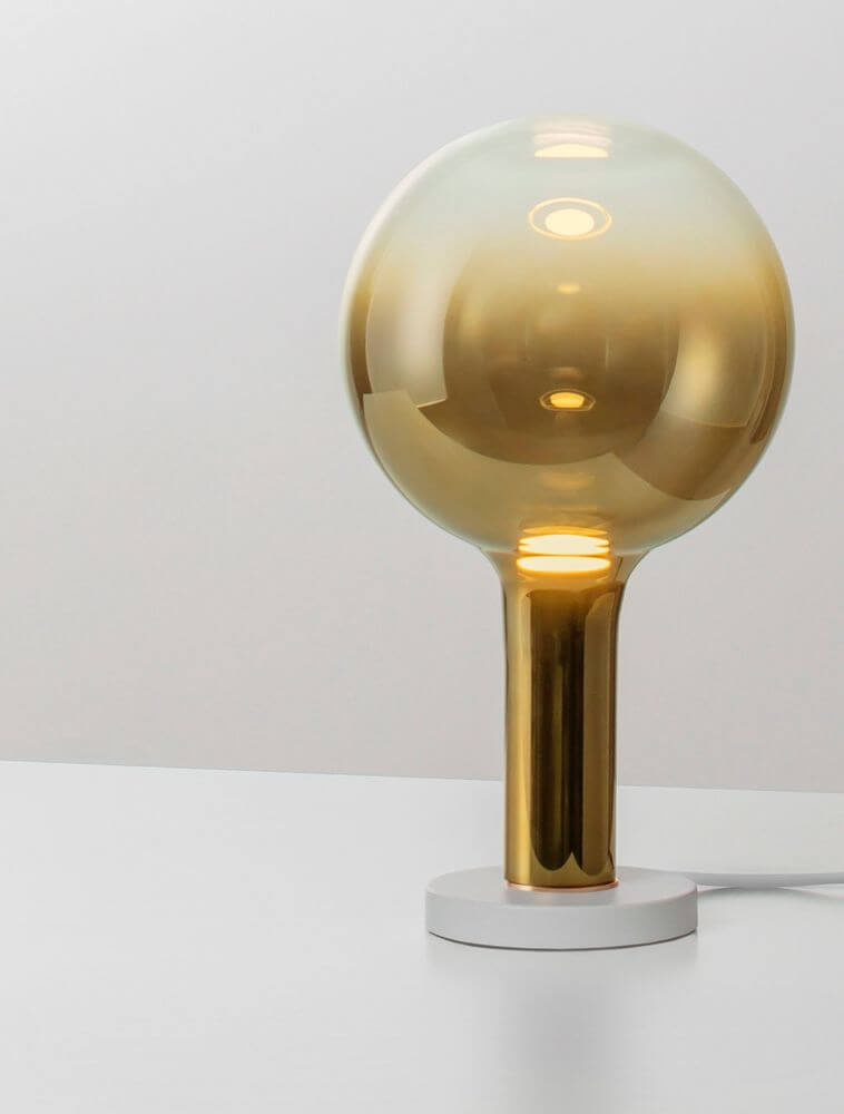 Nostos LED Tischleuchte Ø 20cm 3000K in modernem Design mit getöntem Glas und goldenem Metall.
