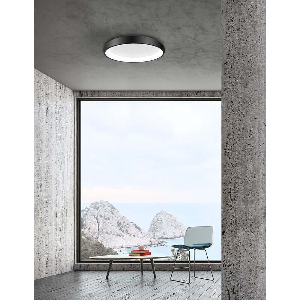 Albi LED Deckenleuchte Dimmbar in modernem Wohnraum mit Meerblick und minimalistischer Einrichtung.