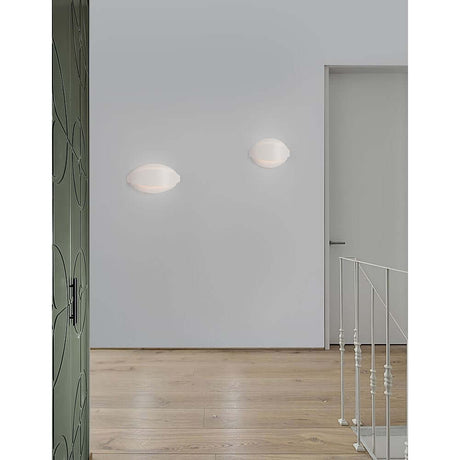 Astrid LED wall light on a modern wall in the hallway, emits warm white light.